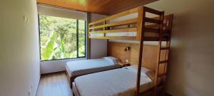 two bunk beds in a room with a window at Balcón de Mindo in Mindo