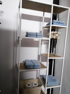 ein weißes Regal mit blauen Handtüchern im Bad in der Unterkunft Studio Apartman Sun in Jajce