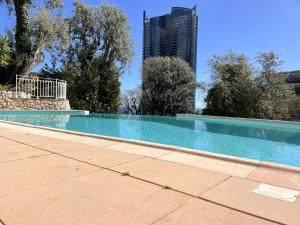 a swimming pool with a city in the background at NEW Studio, piscine et vue mer • proche de Monaco in Beausoleil