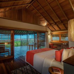 a bedroom with a bed and a view of the ocean at Jaguaríndia Village in Fortim