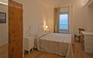 um quarto com uma cama e uma grande janela em B&B Tre Finestre sul Mare em Grottammare