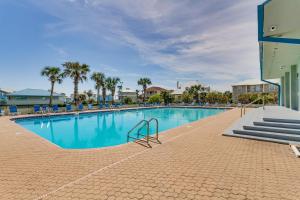una piscina con palmeras y un edificio en Pensacola Beach Vacation Rental with Private Balcony, en Gulf Breeze