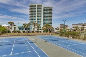 una pista de tenis frente a un edificio alto en Pensacola Beach Vacation Rental with Private Balcony, en Gulf Breeze