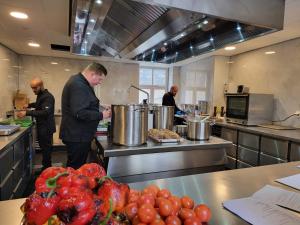 a group of men standing in a kitchen preparing food at Hotel Crasborn Thorn in Thorn