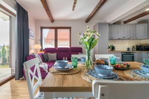 a kitchen and dining room with a table and chairs at Domki Mazurska Dolina in Mikołajki