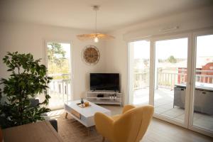 una sala de estar con un televisor y una mesa en Domaine de Milhà, en Labenne