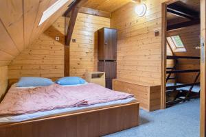 a bedroom with a bed in a wooden cabin at Chalupa Na Paloučku in Orlické Záhoří 