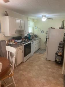 a kitchen with white cabinets and a white refrigerator at Charleston, SC themed - PRIVATE 1 QUEEN BED 1 BATH APARTMENT 2 FUTONS THAT FOLD OUT FLAT TO SLEEP ON & LEATHER LOVE SEAT GAS LOGS IN LIVING ROOM FULL KITCHEN POKER BUMPER POOL TABLE CONVENIENTLY LOCATED IN COLUMBIA SOUTH CAROLINA 1 QUEEN BED & 2 SOFA BEDS in Columbia