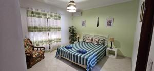 - une chambre avec un lit et une chaise dans l'établissement Villa Vista Mar - Galé - Albufeira, à Guia