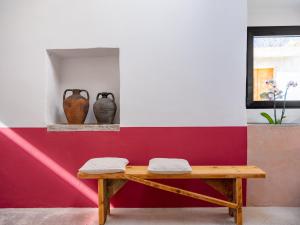 una panchina in una stanza con due vasi su un muro di Binzas betzas Agriturismo a Sedilo