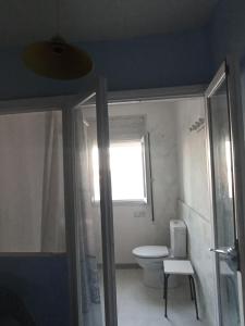 a bathroom with a toilet and a window at Can ventura in Deltebre