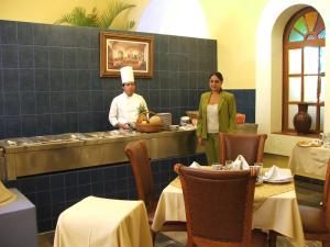 a man and a woman standing in a restaurant at Hotel Casa Real Tehuacan in Tehuacán