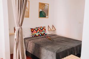 um quarto com uma cama com um cobertor cinzento em Pousada Bom Sucesso 59 em Olinda