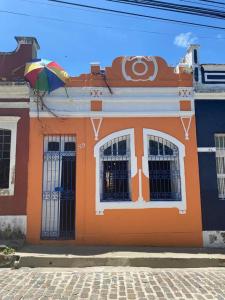 奧林達的住宿－Pousada Bom Sucesso 59，一座橙色的建筑,上面有一把伞