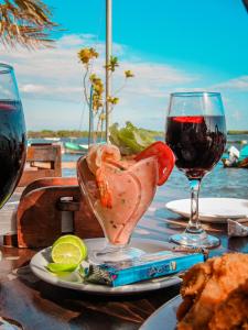 a table with a plate of food and wine glasses at Hotel Restaurante Spa La Barca de Oro in Las Peñitas