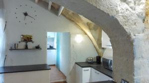 a kitchen with a clock on the wall at Maison Troglodyte en Provence in Fontvieille