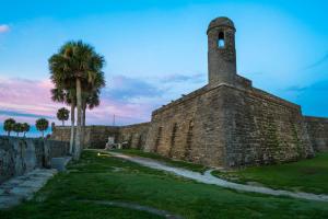 a brick wall with a tower and a palm tree at Whale Tale - B in Fernandina Beach