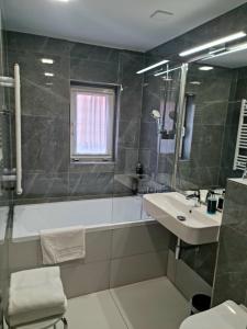 y baño con lavamanos, bañera y lavamanos. en Pension Vltavín, en Český Krumlov