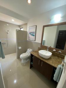 a bathroom with a sink and a toilet and a mirror at Villas Eco Venture in Playa Junquillal