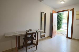 een kamer met een tafel, een stoel en een spiegel bij Exclusivo Adosado en Punta Coral El Rompido in El Rompido