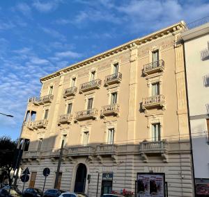 un gran edificio amarillo con balcones en una calle en Armonia B&B, en Lecce