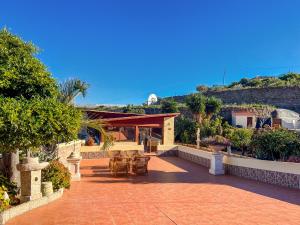 a house with a patio with tables and chairs at Exquisite rural house with garden, pool and sea views in Arico Viejo