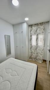a bedroom with a white bed in a room at Rockside Residences Suites La Línea N3 in La Línea de la Concepción