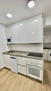 a kitchen with white cabinets and a stove top oven at Rockside Residences Suites La Línea N3 in La Línea de la Concepción