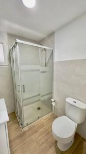 a bathroom with a toilet and a glass shower at Rockside Residences Suites La Línea N3 in La Línea de la Concepción