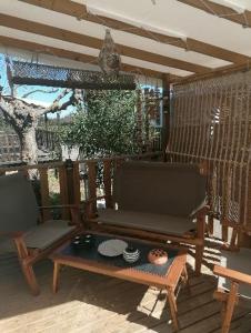 une terrasse couverte avec 2 chaises et une table. dans l'établissement Mobil-Home Cosy Climatisé 3 chambres, à Vic-la-Gardiole