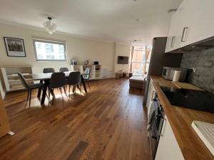 cocina y sala de estar con mesa y sillas en Ultra-Luxury City centre 2 bed apartment, with FREE parking, en Cardiff
