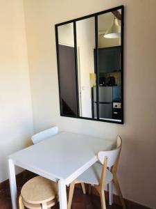 a white table and chairs in a room with a mirror at DUPLEX EN PLEIN COEUR DU VILLAGE in Cassis