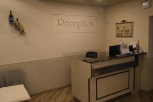 a reception desk in a room with a sign on the wall at Amelia Hotel in Momigno
