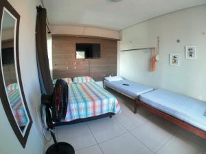 ein Schlafzimmer mit einem Bett und einem TV. in der Unterkunft Casa para Família com Piscina in Luis Correia