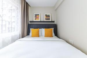 a bedroom with a bed with yellow pillows and a window at rnished M in Istanbul