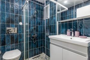 a blue tiled bathroom with a toilet and a sink at rnished M in Istanbul