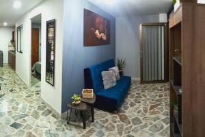 uma sala de estar com um sofá azul e uma mesa em Aparta- estudio Ziruma 102 em Medellín