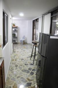 een keuken met een koelkast in het midden van een kamer bij Aparta- estudio Ziruma 102 in Medellín