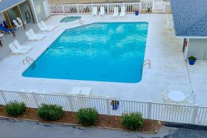 an overhead view of a large swimming pool with chairs at IBCS02 Colony by the Sea #201 in Indian Beach