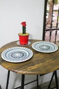 two plates on a wooden table with a plant at Aparta- estudio Ziruma 102 in Medellín
