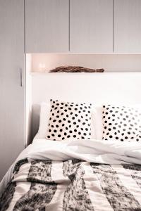 a white bed with a black and white comforter at [Ferrara Centro - SABI APT] in Ferrara