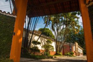 a view of a house with palm trees in front of it at Pousada Chácara Maria da Graça in Tremembé