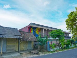 a building with colorful paint on it next to a street at OYO 92377 Wisma Melyro Syariah 