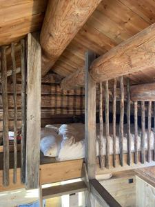 a bunk bed in a cabin with wooden ceilings at Sauefjøset - Idyllisk gardstun fra 1800-tallet in Skjåk
