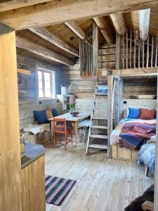 1 dormitorio con 1 cama y 1 mesa en una habitación en Sauefjøset - Idyllisk gardstun fra 1800-tallet en Skjåk