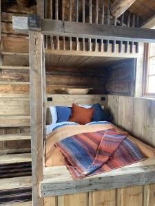 a wooden bunk bed in a log cabin at Sauefjøset - Idyllisk gardstun fra 1800-tallet in Skjåk