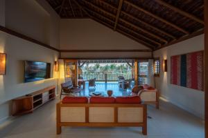 a living room with a couch and a tv at Jaguaríndia Village in Fortim