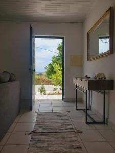 Vale Covo的住宿－A casa da Laranjeira，一间设有桌子、镜子和门的房间