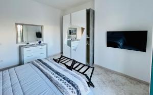 a bedroom with a bed and a tv on a wall at Infinity Experience Casa Vacanza Incantevole con Terrazzo in Scala
