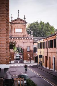 a person riding a bike in front of a building at [Ferrara Centro - SABI APT] in Ferrara